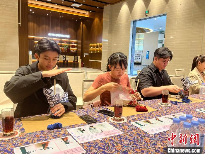 老挝青年品六堡茶制艾草锤 领略独特壮乡魅力