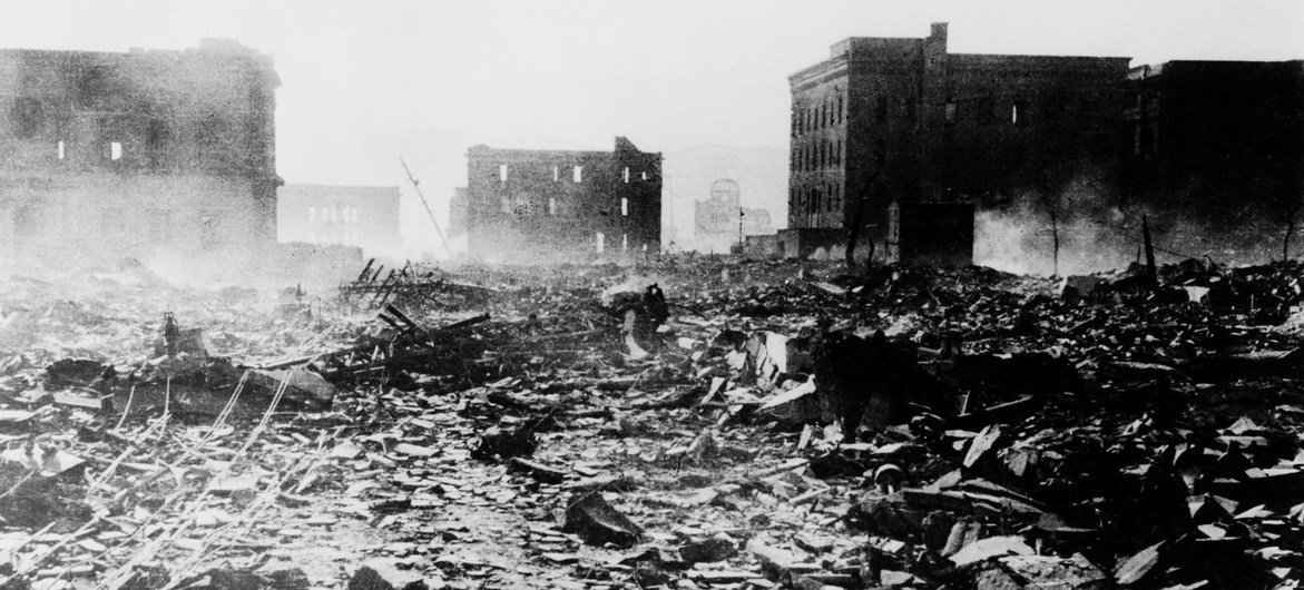 一张黑白照片展示了 1945 年日本广岛原子弹爆炸后的废墟与破坏景象,背景中的原子弹圆顶在断壁残垣中清晰可见。